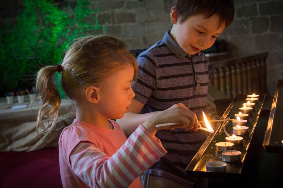 Two children lighting candles