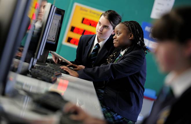 two secondary school children sitting at a computer 