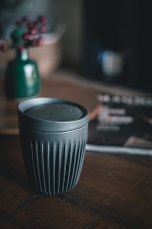 A reusable coffee cup on wooden table.