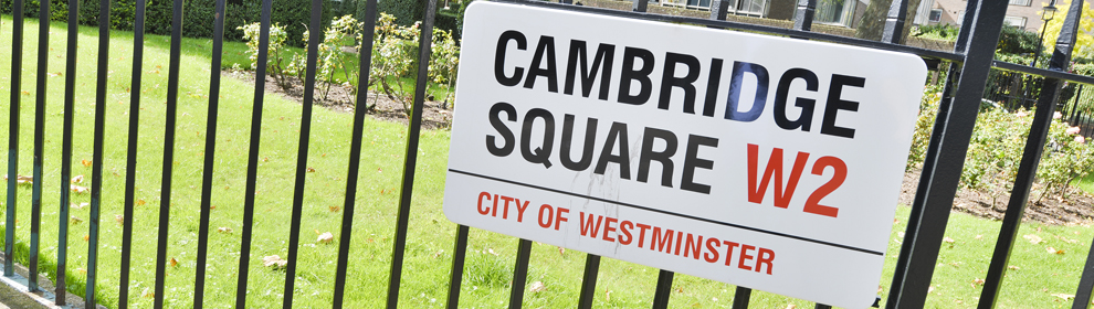 A street sign with the words "Cambridge Square W2 - City of Westminster" on metal railings.