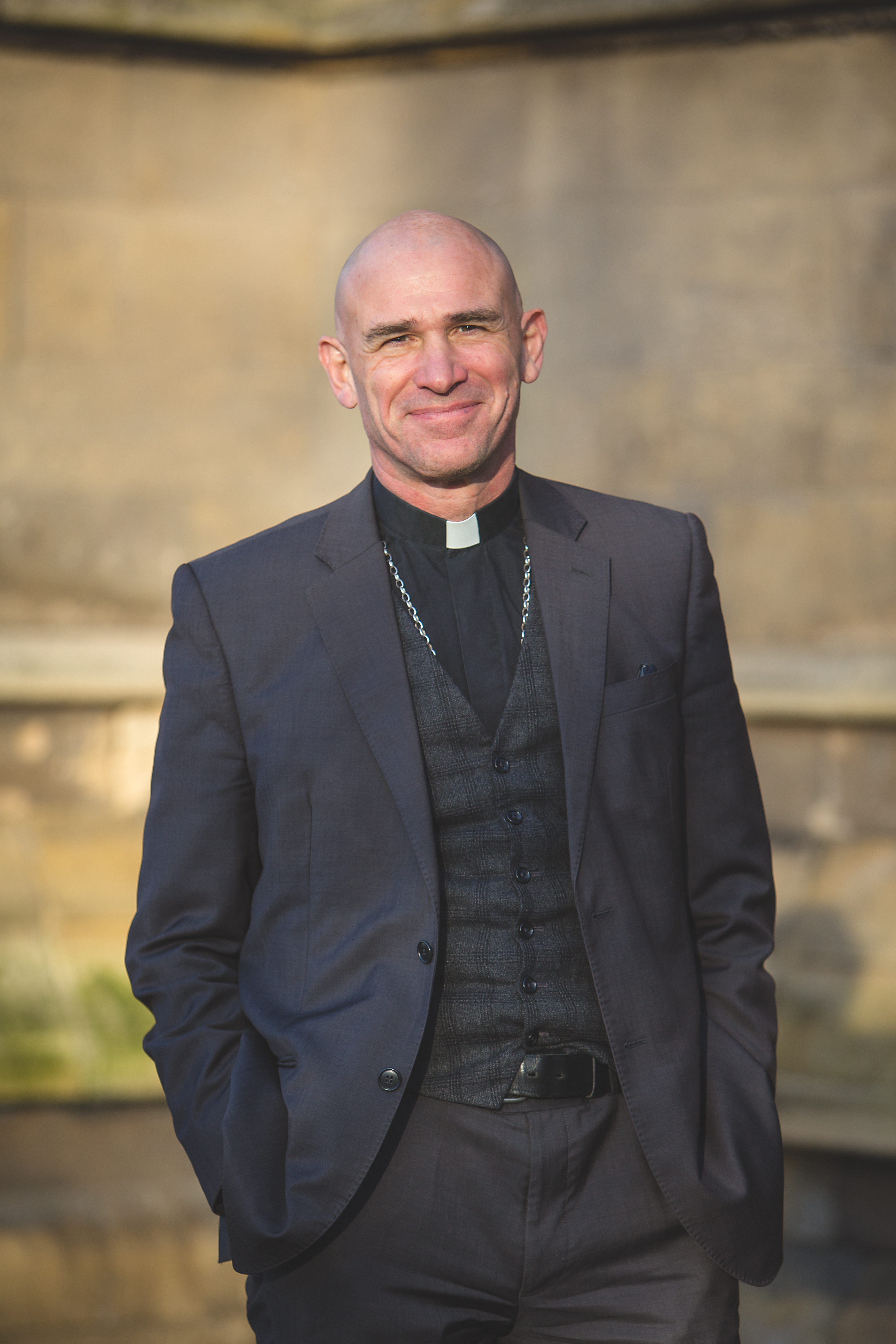 The Rt Revd Dr Pete Wilcox, Bishop of Sheffield is shown standing in a black suit with a clerical collar on 