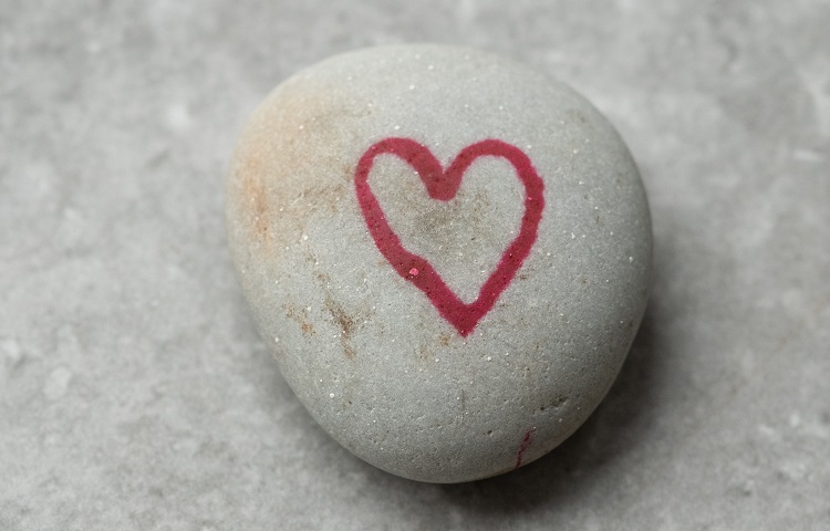 A pebble painted with a red heart