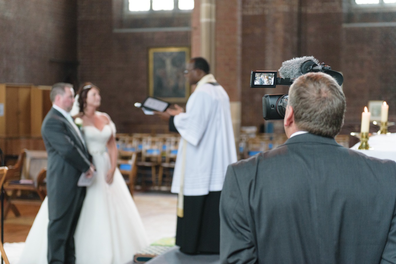 A videographer filming a wedding in church