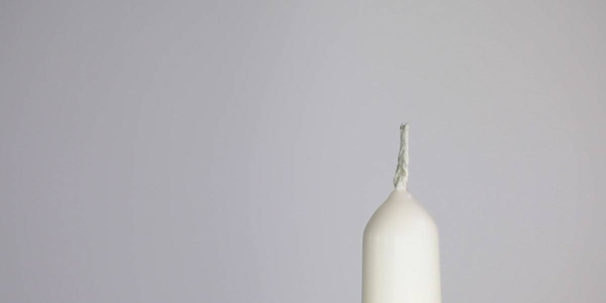 An unlit white candle