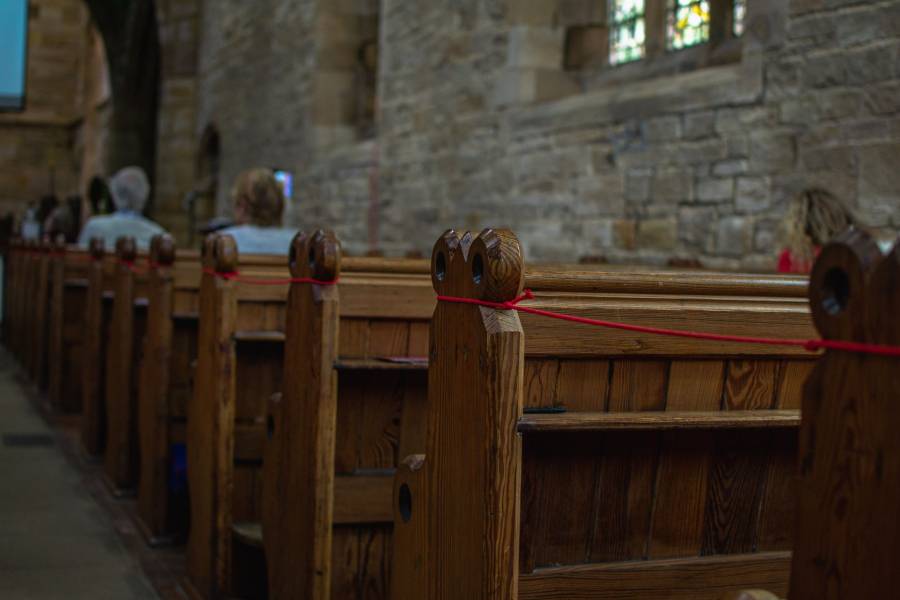 Pews within a church with people socially distant