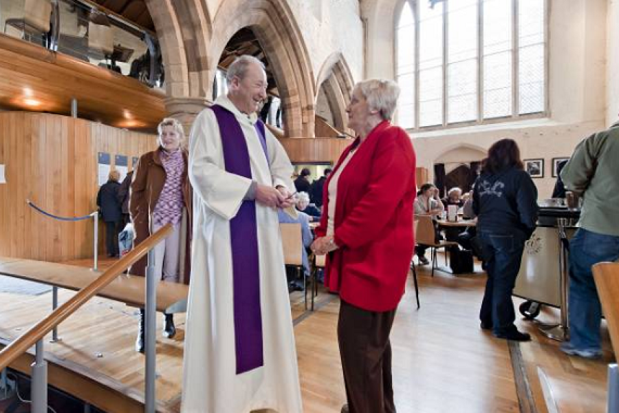Vicar greeting a parishioner in a church