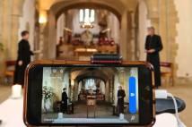 Portsmouth Cathedral clergy record on a phone a service ready to be streamed online
