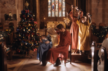 A still from the film showing a family in a nativity scene in a church