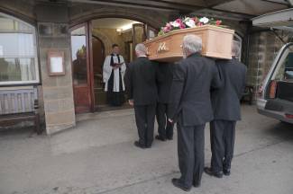 Pallbearers carrying coffin into church