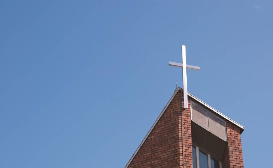 A cross on the roof of a modern church building