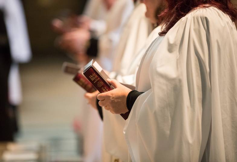 Profile of female clergy member holding bible 