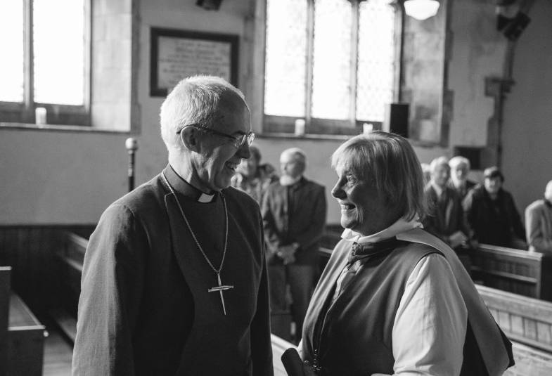 Archbishop of Canterbury laughing with lady in church 