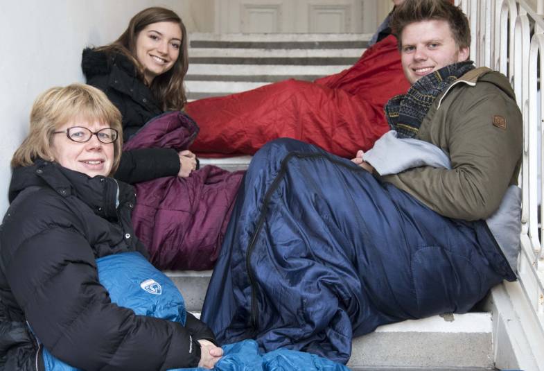 Bishop Sarah Mullally in sleeping bag on stairs with others