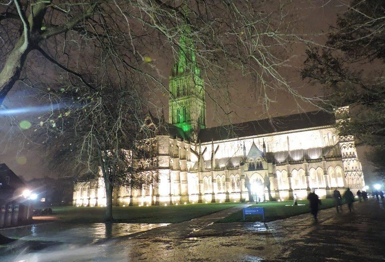 Salisbury Cathedral at night with its spire lit up in Green 