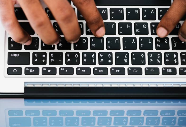 close up of hands typing on laptop
