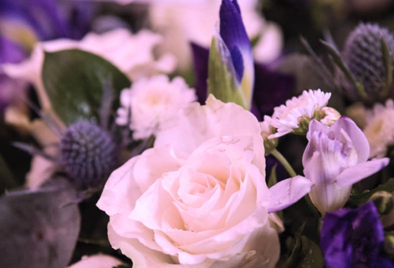 Flowers at a funeral with a purple tint.
