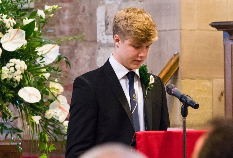 A teenage boy doing a reading in church at the lectern