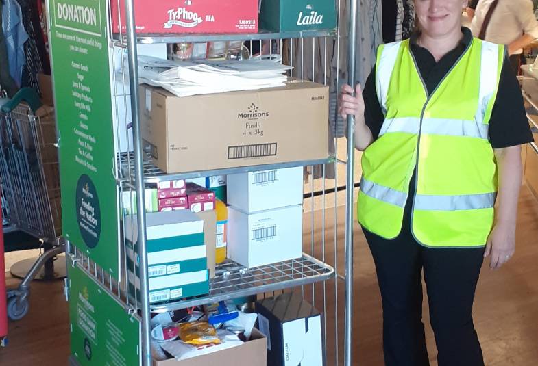 A woman poses with donations in a supermarket trolley 