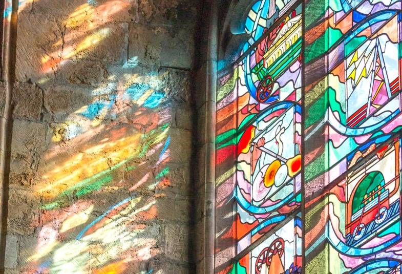 Stained glass windows from Durham Cathedral shine a beautiful polychromatic effect on a wall