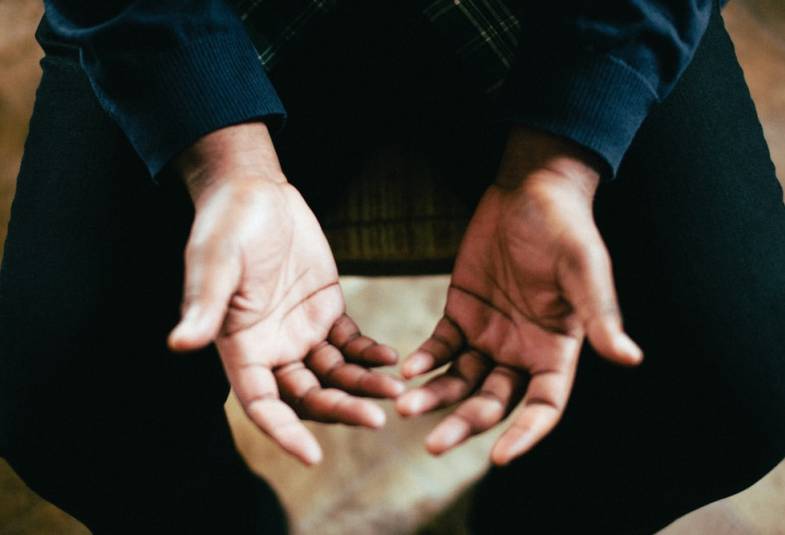 A man places his hands out in prayer