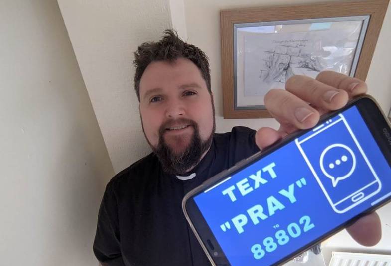 Man with text pray on phone