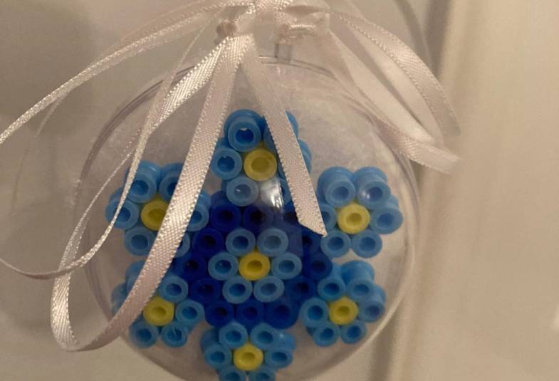 A forget-me-not item made by those with dementia is shown hanging by a thread