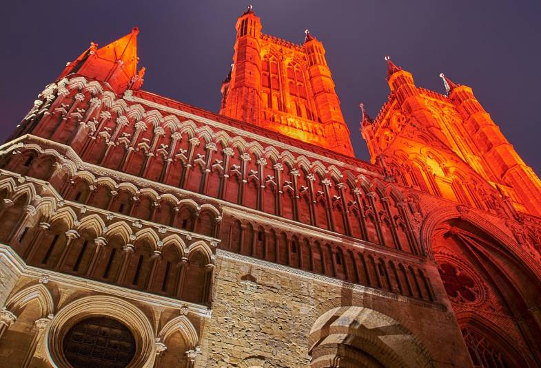 Lincoln Cathedral is shown bathed in red lights 