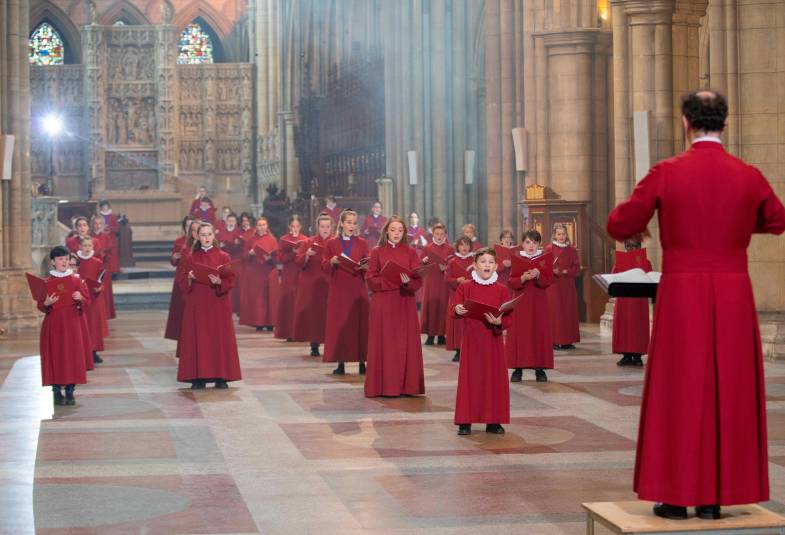 Truro Cathedral choristers are shown in red singing the Gee Seven song