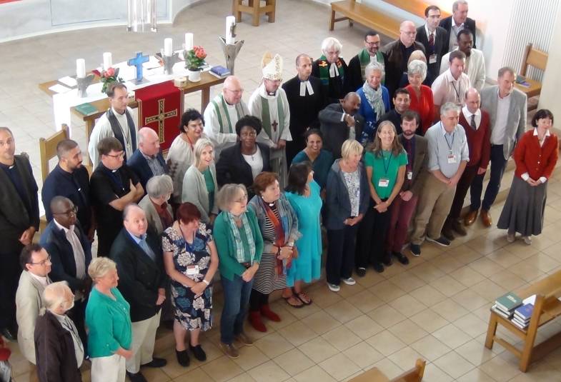 Three rows of parishioners are shown from above with the bishop of Europe in the centre