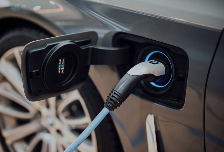 A church electric charger is shown with a plug into the side of an electric car