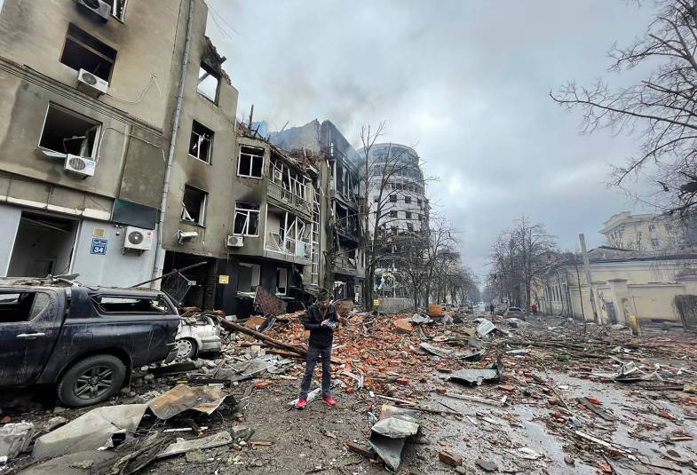 Man standing on the street in Kharkiv, Ukraine, amid bomb damage 