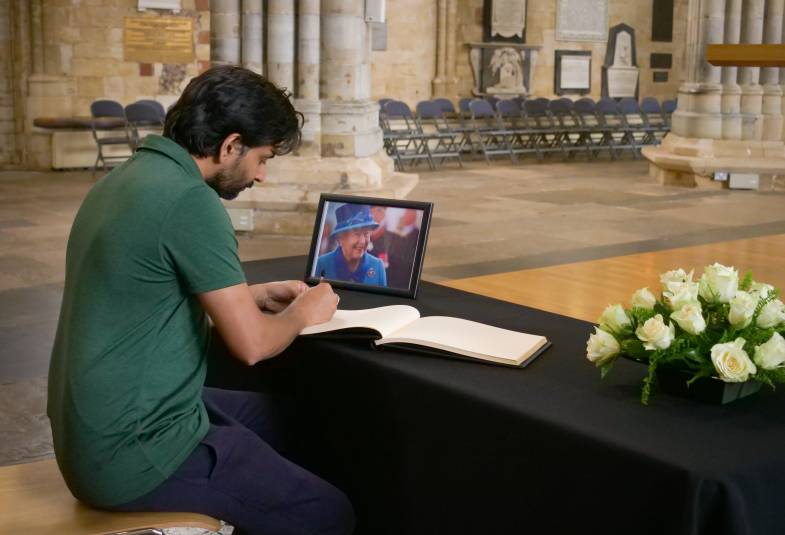 A man signing book of condolence in Exeter Cathedral