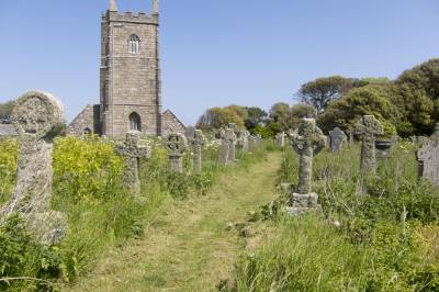 Flowers are shown next to graves in a church yard a church tower is also shown on the left hand side