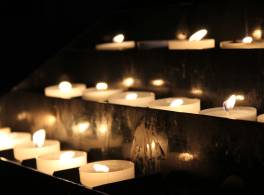 Rows of tealight candles in the darkness