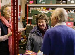 Three volunteers talking to each other inside a foodbank