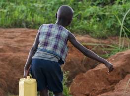 African child carrying water carrier 