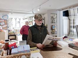 Man buying paper inside church shop