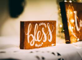 A wooden block with the word 'bless' written on it.