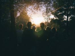 A group of people looking at a sunrise.