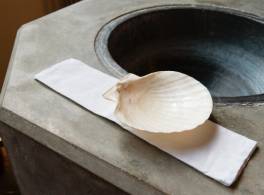 Scallop shell on the side of a baptism font.