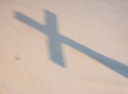 Shadow of cross thrown across white cloth