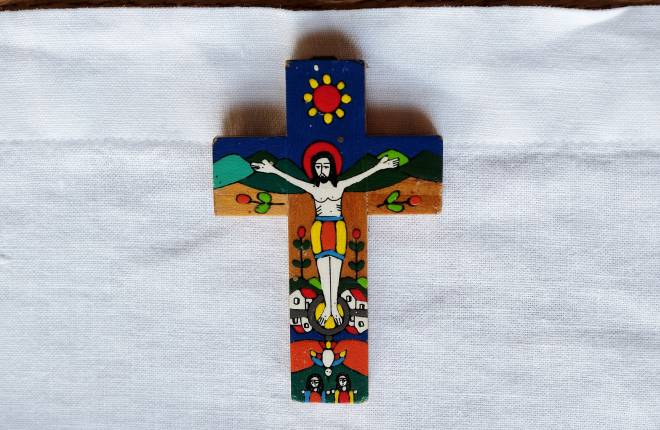 Colourful Romero cross laying on white cloth