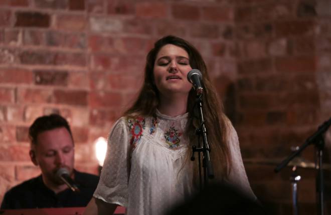 Young woman singing into microphone at service 
