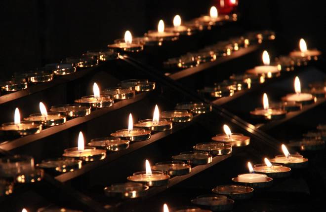 Rows of tealight candles, half lit
