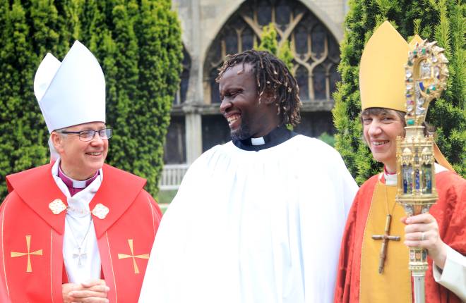 new clergy member with a bishop standing either side 
