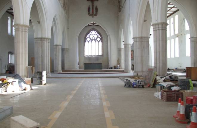 Interior of a church with construction materials and tools layout out in the aisles