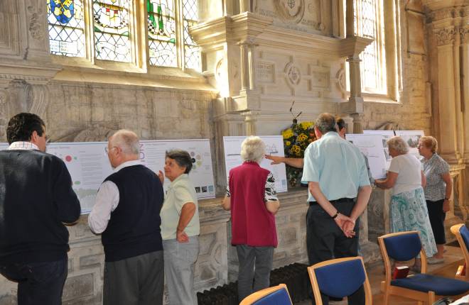 People looking at information panels of the church's development plans