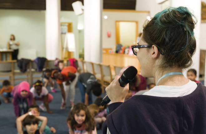 Young leader talking to children at a church holiday club