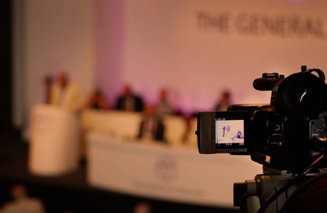 A camera pointing to the stage at General Synod.
