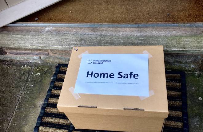 A Home safe parcel sitting outside the front door of someone's house.